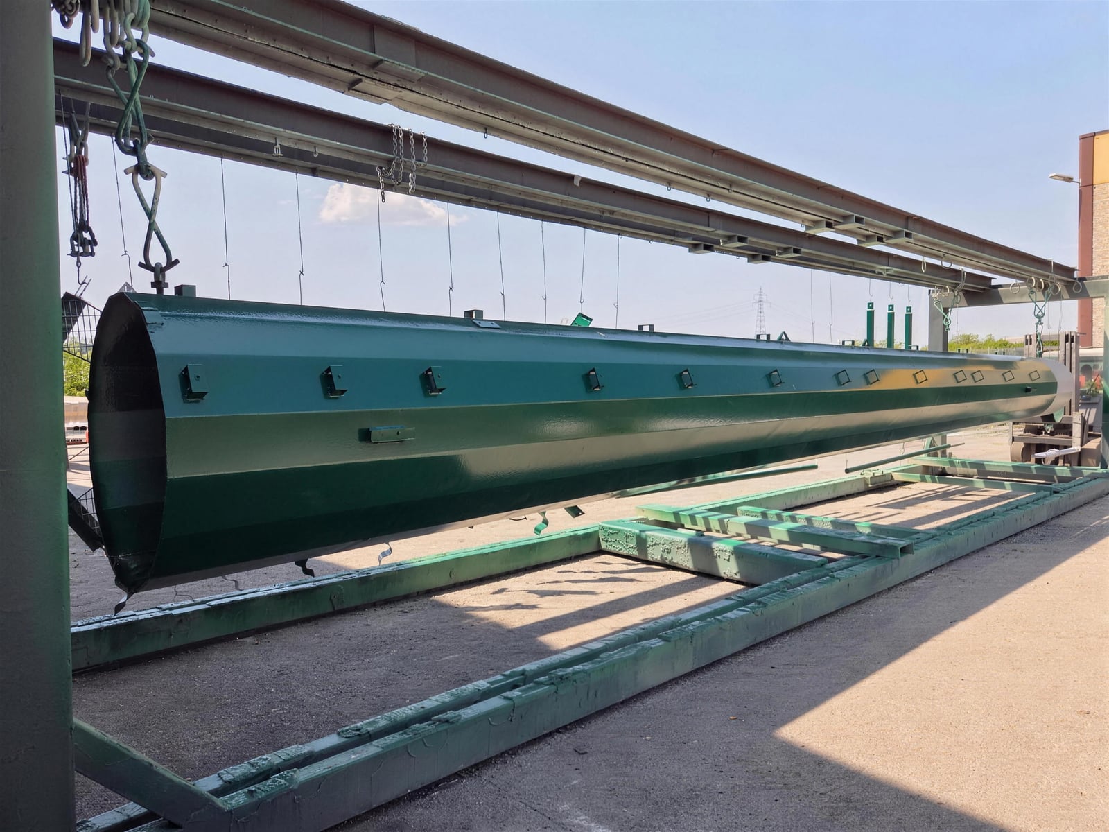 Grande palo monotubolare in acciaio verniciato a polvere verde sulla linea aerea dello stabilimento Æstus Design per Siderpali