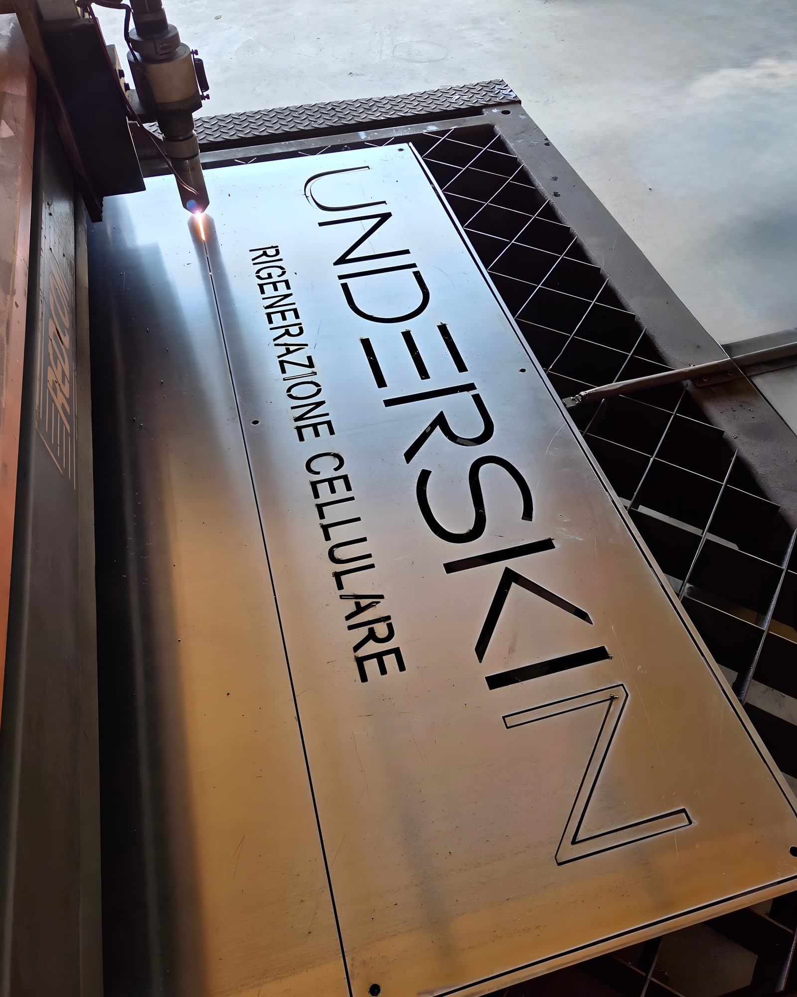 Taglio plasma HD dell'insegna UNDERSKIN nell'officina Æstus Design: il lettering prende forma nella lamiera