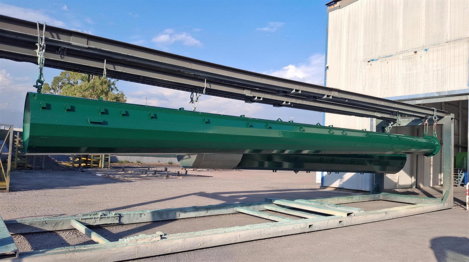Palo monotubolare verniciato a polvere verde appeso alla linea aerea nel piazzale Æstus Design